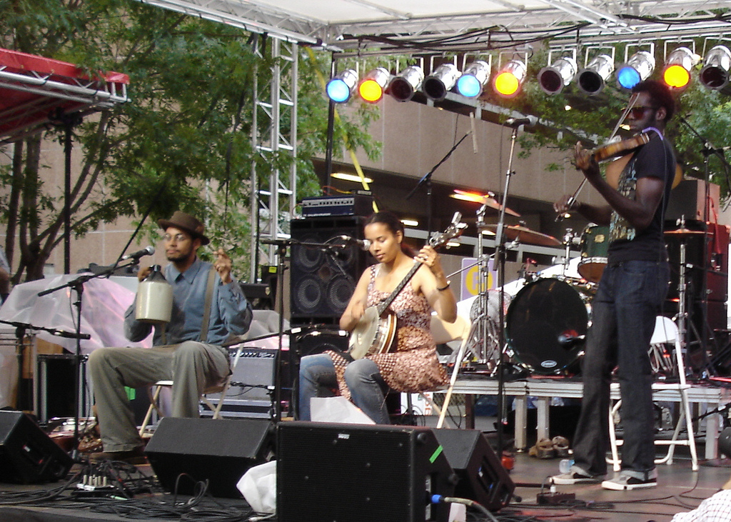Carolina Chocolate Drops performing with banjo, fiddle, and jug at an outdoor folk festival