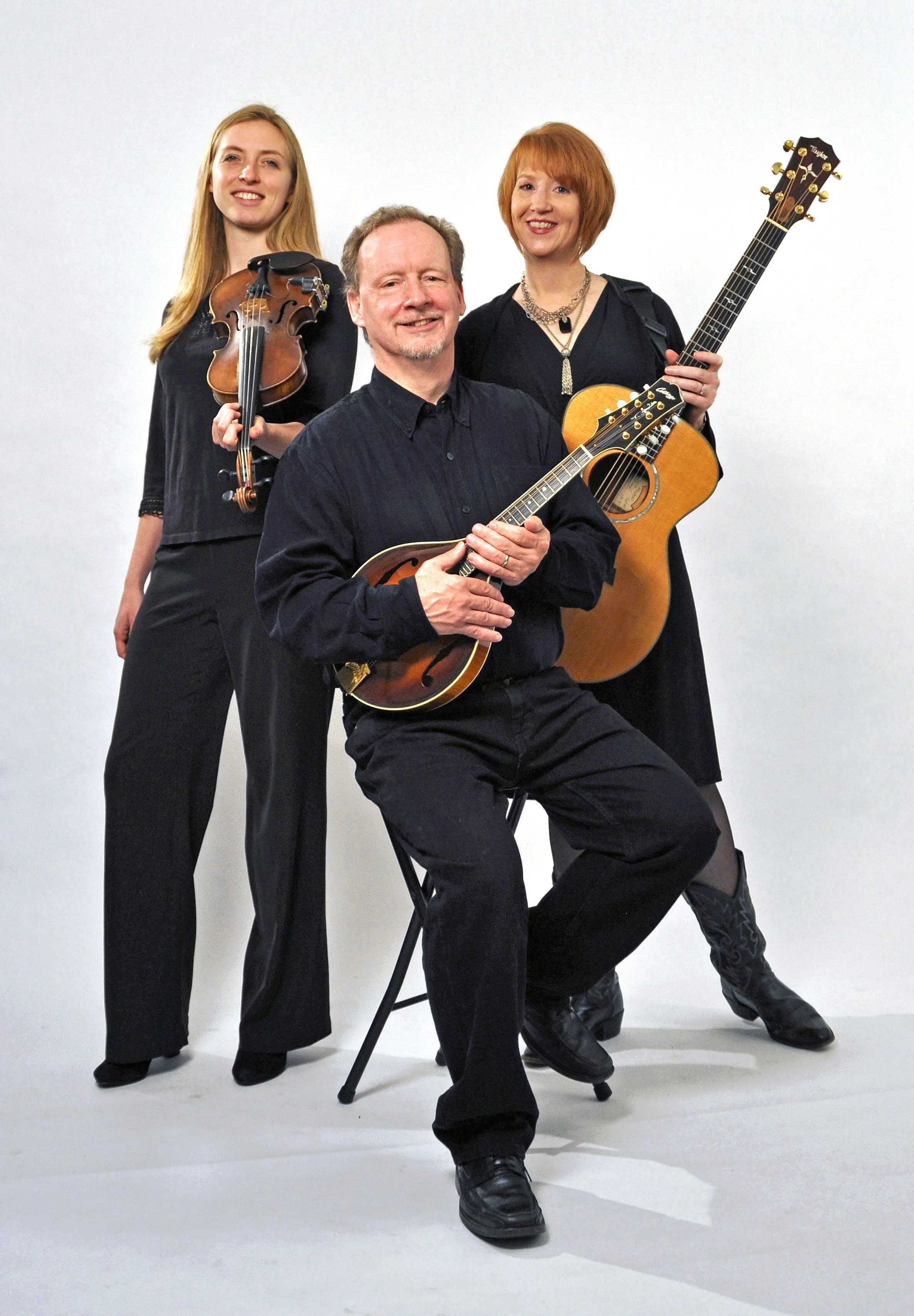Three folk musicians performing together with fiddle and acoustic instruments in Cincinnati